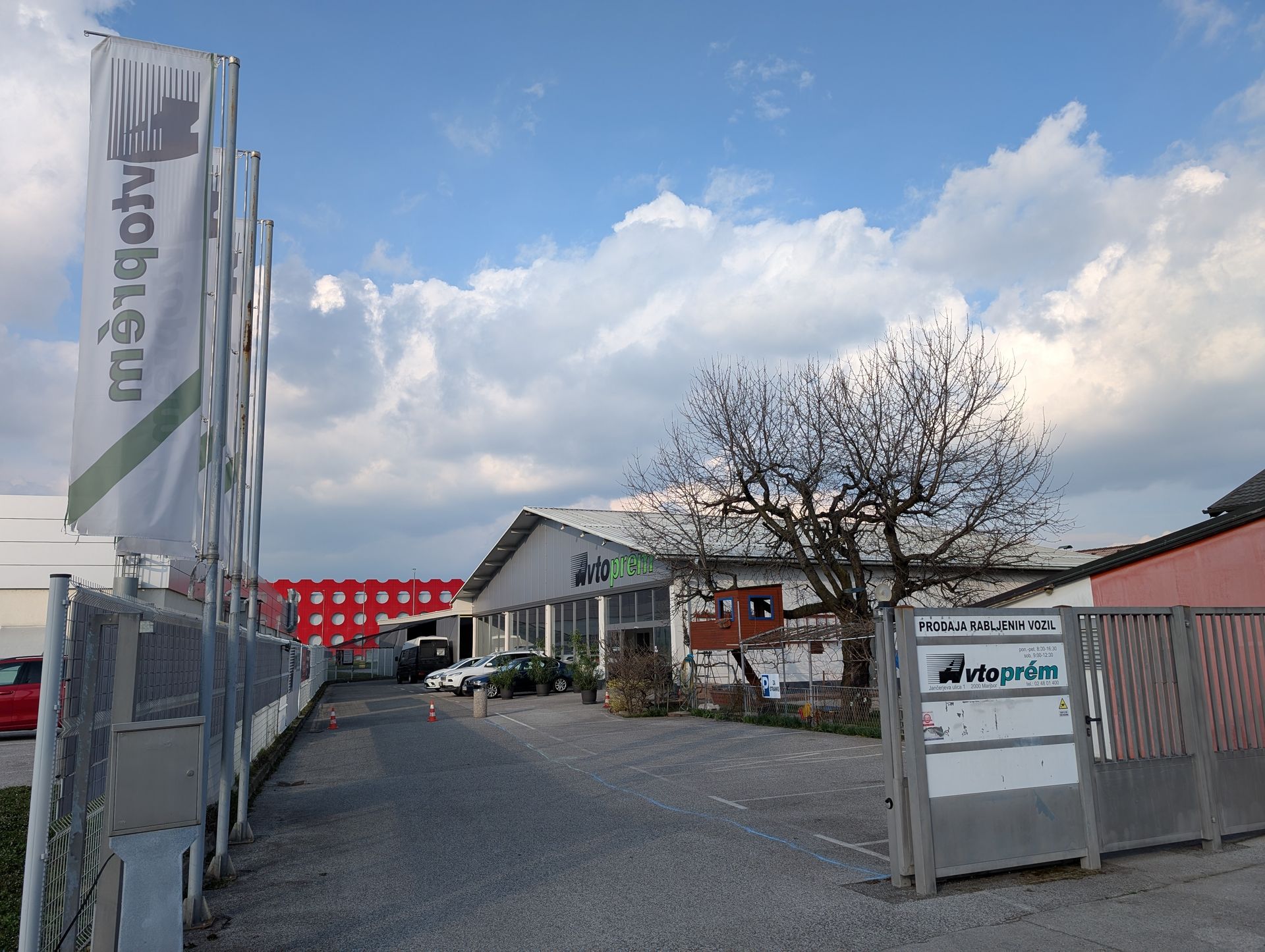 Vhod v salon Avtoprem z zastavo in napisom Prodaja rabljenih vozil